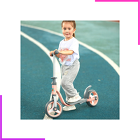 Enfant roulant sur la trottinette deux roues sur une piste